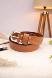 Brown leather belt with silver buckle on a light surface with a lamp in the background